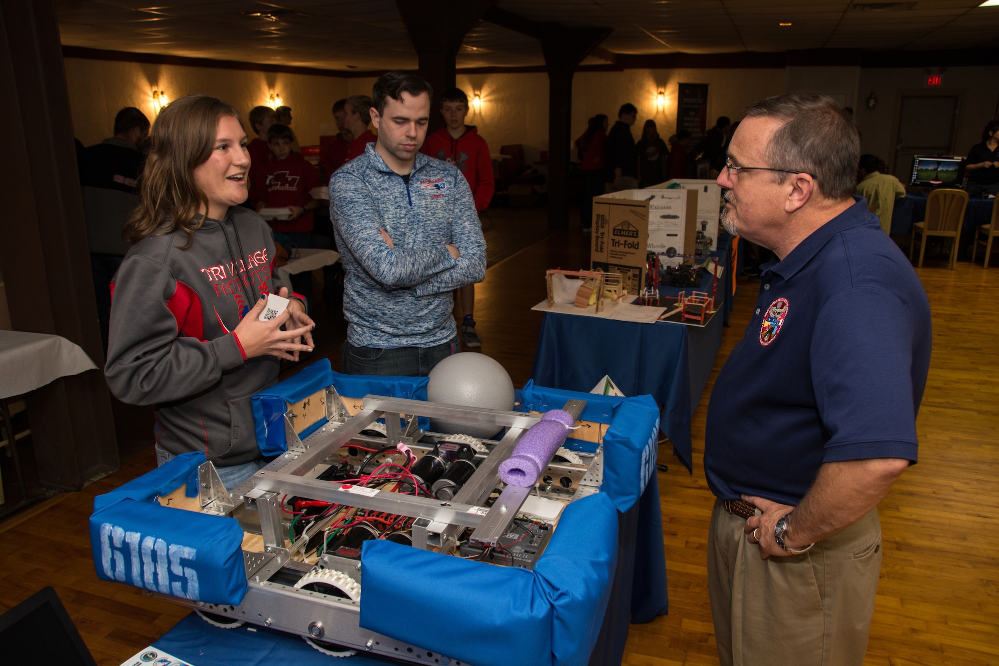 A student from Tri Village High School discusses her STEM project with Winston “Wink” Bennett, technical advisor for the Warfighter Readiness Research Division in the 711th Human Performance Wing, during the Full Throttle STEM® at Eldora Day May 10 at Eldora Speedway in Rossburg, Ohio. (U.S. Air Force photo/Richard Eldridge)