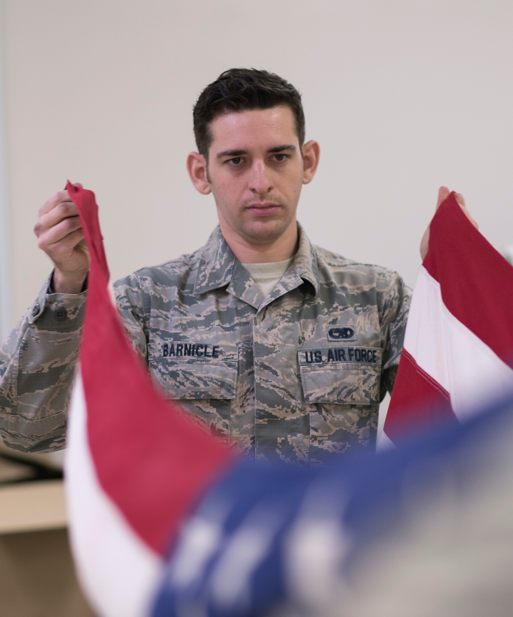 Staff Sgt. Patrick Barnicle, Yokota Honor Guard, holds an American flag during honor guard training at Yokota Air Base, Japan, May 11, 2016. New trainees join Honor Guard every quarter, ensuring they have enough Airmen to perform at ceremonies throughout the year. (U.S. Air Force photo by Staff Sgt. Michael Washburn/Released)