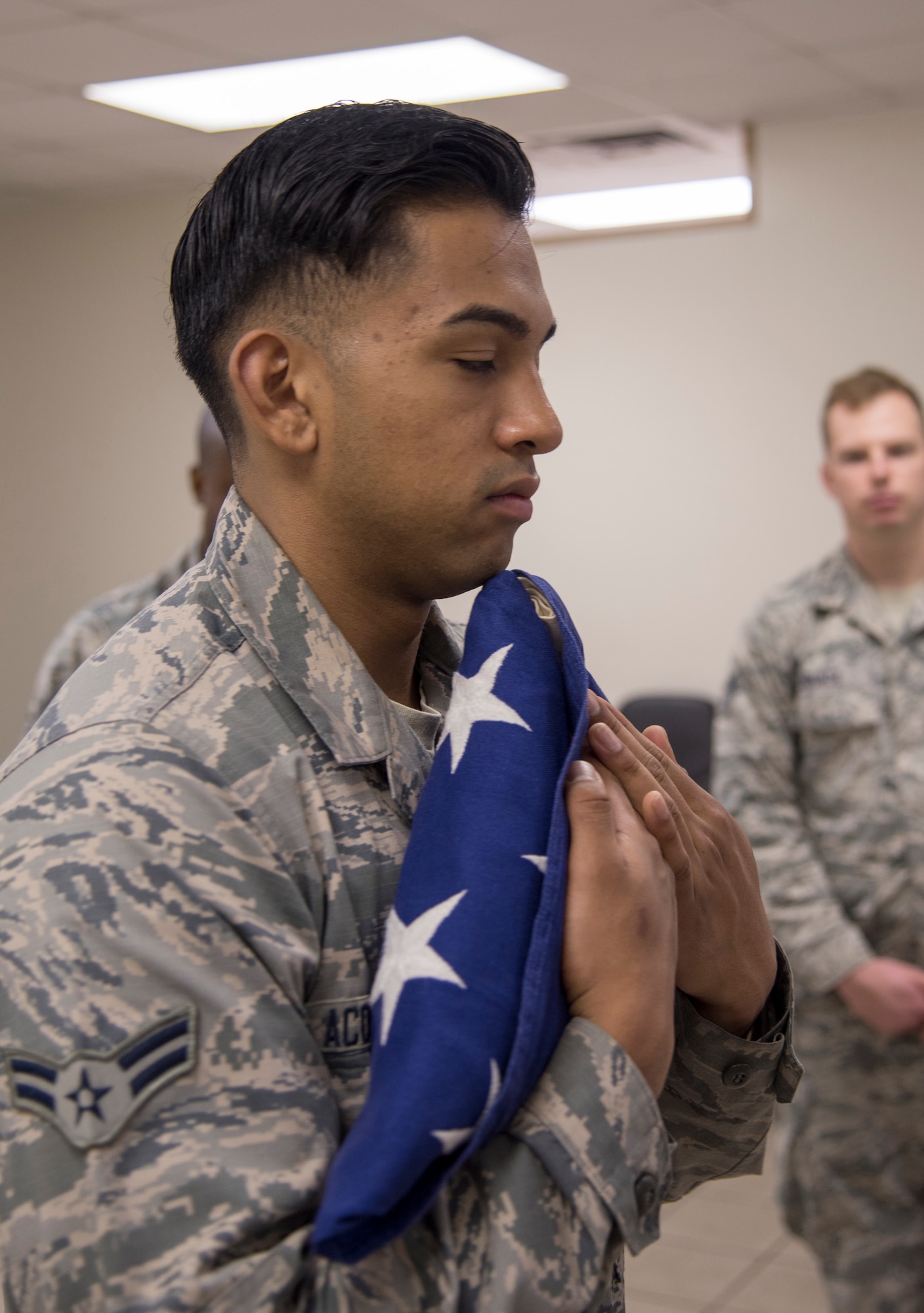 Airman 1st Class Joshua Acosta-Radilla, Yokota Honor Guard, holds a folded American flag during honor guard training at Yokota Air Base, Japan, May 11, 2016. It takes about three months to train an Airman to be ready for Honor Guard duties. (U.S. Air Force photo by Staff Sgt. Michael Washburn/Released)
