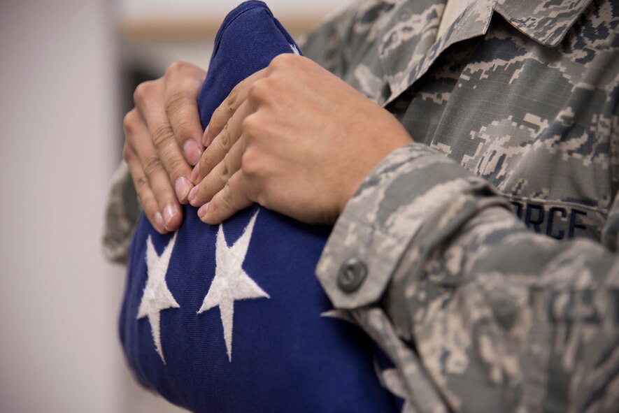 Senior Airman Samuel Jones, Yokota Honor Guard, holds a folded American flag during honor guard training at Yokota Air Base, Japan, May 11, 2016. The folded flag was used to practice a military funeral ceremony. (U.S. Air Force photo by Staff Sgt. Michael Washburn/Released)