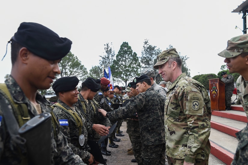 U.S. Army Col. Robert Harman (right), Joint Task Force-Bravo commander, congratulates a graduate of a Task Force-Caiman-sponsored Regionally Aligned Forces-Central America training course in Tamara, Honduras, April 30, 2016. Leadership from U.S. Army South, Regionally Aligned Forces-CENTAM, JTF-Bravo and the Honduran Army attended the closing ceremony to show their support to everyone involved with the course. (U.S. Air Force photo by Staff Sgt. Siuta B. Ika)