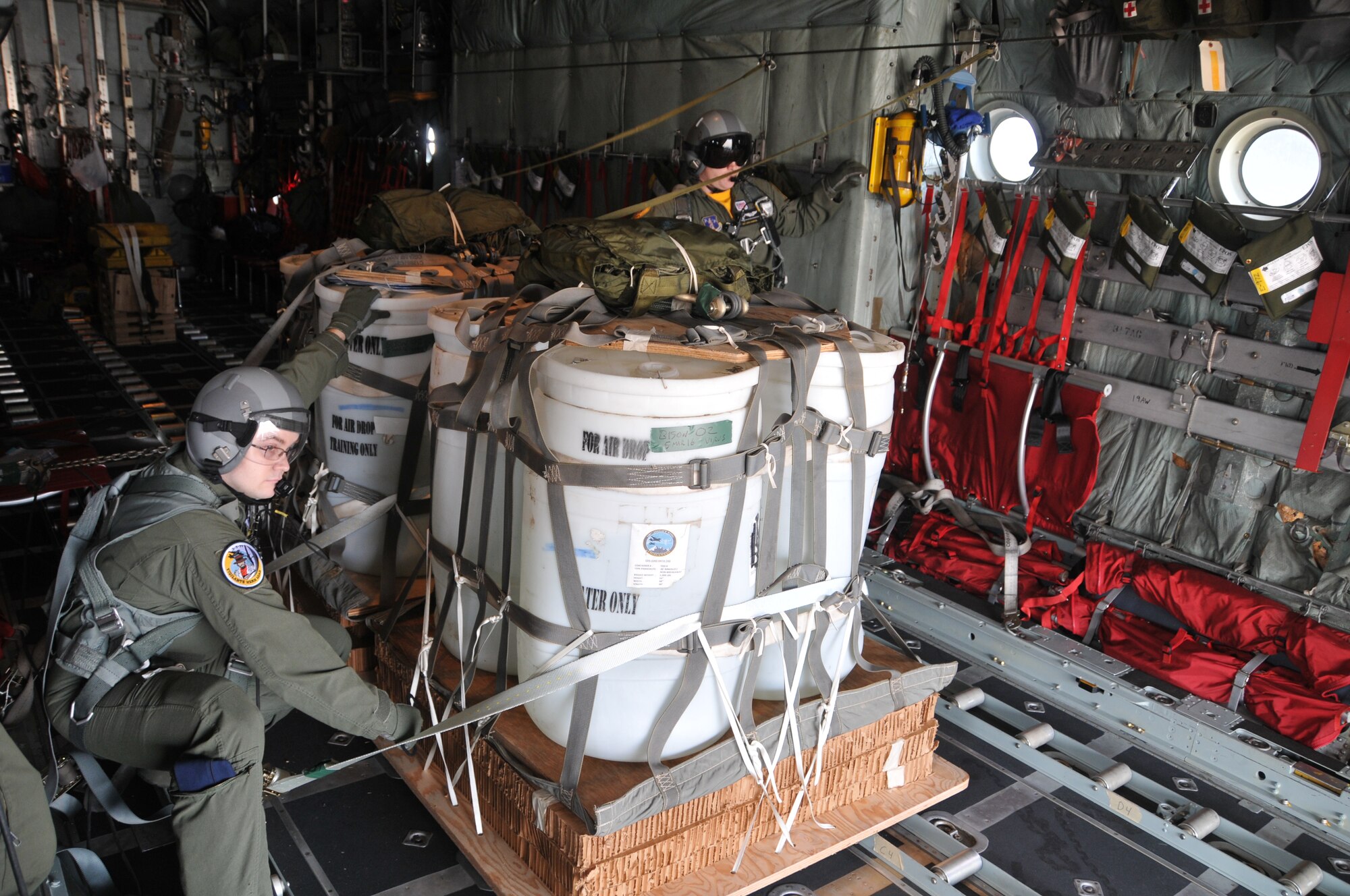 A loadmaster from the 186th Airlift Squadron prepares to release a training cargo load aboard a Montana Air National Guard C-130 cargo aircraft over the drop zone Chargin' Charlie at Malmstrom Air Force Base, Mont. March 5, 2016. Each load weighs nearly 1,000 pounds and was dropped from 1500 feet. (U.S. Air National Guard photo/Tech. Sgt. Michael Touchette)

