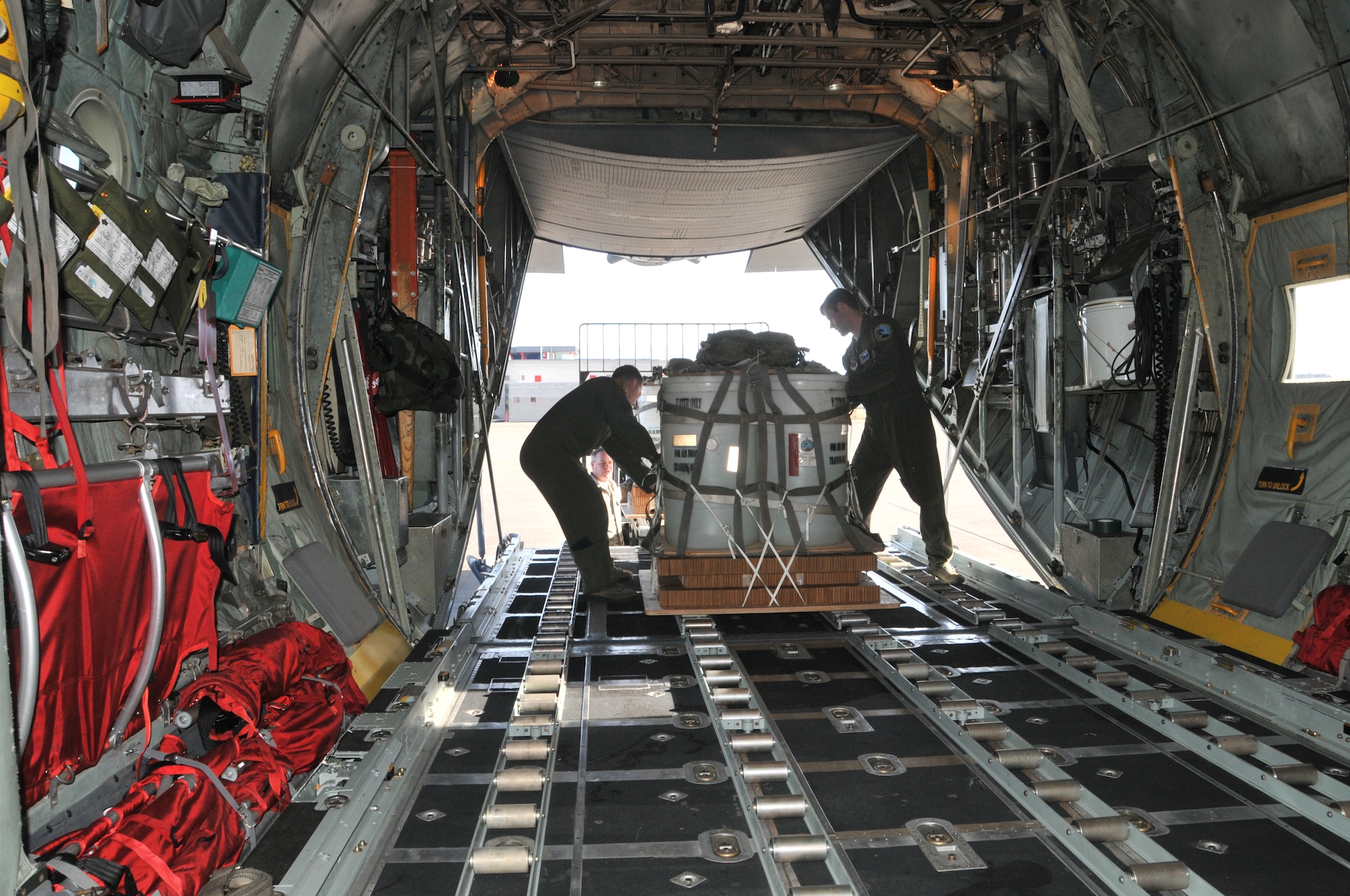 Loadmasters from the 186th Airlift Squadron secure a training cargo load aboard a Montana Air National Guard C-130 cargo aircraft. The cargo was intended to be dropped at the Chargin' Charlie Drop Zone at Malmstrom Air Force Base, Mont. March 5, 2016. Each load weighs nearly 1,000 pounds and was dropped from 1500 feet. (U.S. Air National Guard photo/Tech. Sgt. Michael
Touchette)

