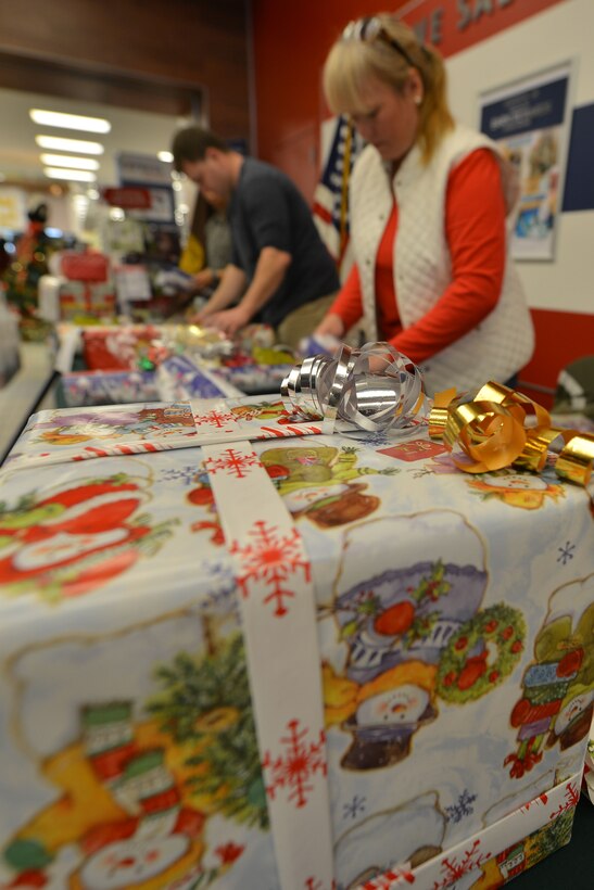 Warrant Officer Association Hampton Roads Chapter volunteers wrap gifts to raise funds for scholarships at Fort Eustis, Va., Dec. 11, 2015. The chapter regularly volunteers as a way to build bonds with local community partners, raise scholarship funds and foster stewardship within the military. (U.S. Air Force photo by Staff Sgt. Natasha Stannard)