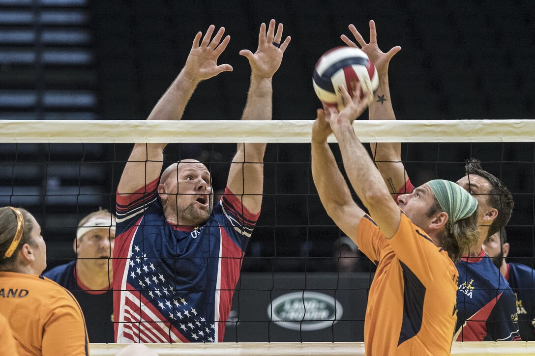 Navy veteran Brett Parks, left, and Army veteran Nicholas Titman attempt to block a shot in a sitting volleyball game against Denmark at the 2016 Invictus Games in Orlando, Fla., May 11, 2016. DoD photo by Roger Wollenberg