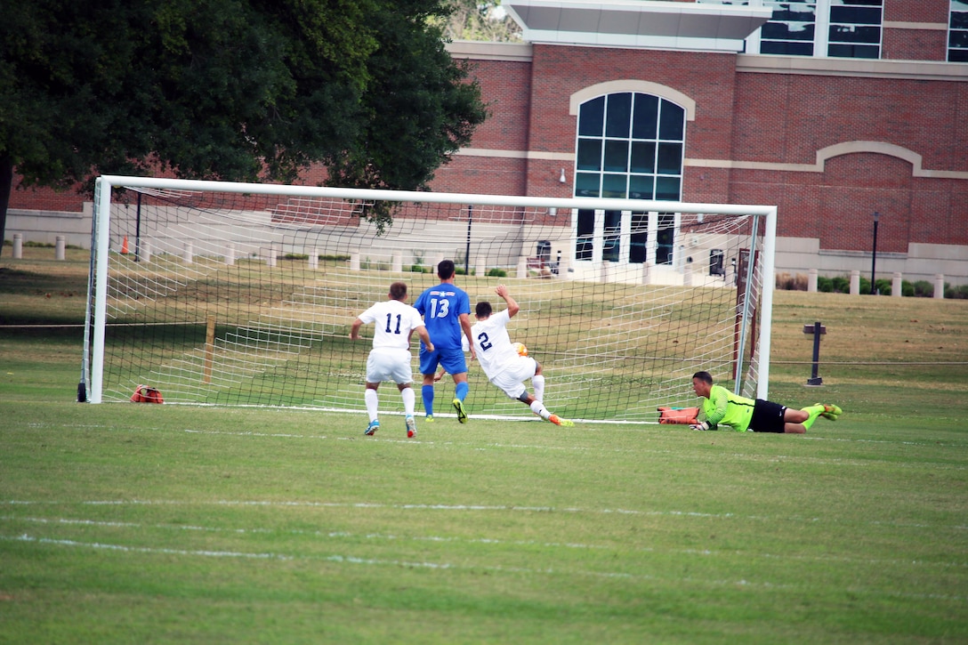 Fort Benning, Ga. - Navy Ensign Alex Wilson (#2) pounds the opening goal of the championship match of the 2016 Armed Forces Men's Soccer Championship hosted at Fort Benning, Ga from 6-14 May 2016.  Air Force would win the Championship 3-2, with Navy taking silver.