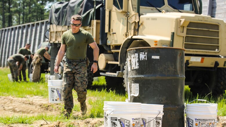 A Marine with 2nd Explosive Ordnance Disposal Company transports a bucket filled with water toward an explosive during a Protective Works Demolition Range at Marine Corps Base Camp Lejeune, North Carolina, May 12, 2016. The semi-annual training provides EOD with the opportunity to locate areas in need of improvement to ensure they are prepared for future contingencies. 