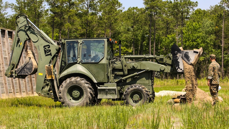 A Marine with 2nd Explosive Ordnance Disposal Company observes as a TRAM covers an explosive site with dirt during a Protective Works Demolition Range at Marine Corps Base Camp Lejeune, North Carolina, May 12, 2016. The EOD technicians were tasked to practice methods of protective works that allow them to reduce the fragmentation of explosives to preserve their surroundings. 
