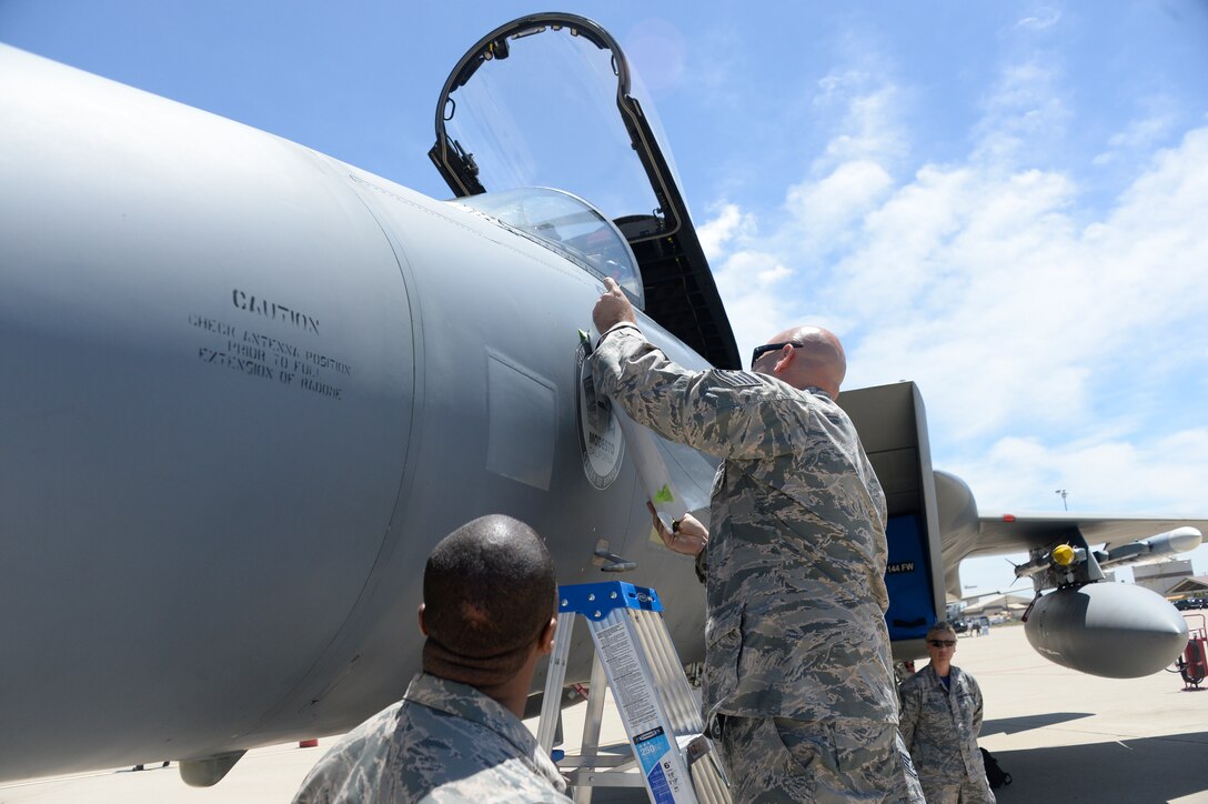 A U.S. Air Force F-15 Eagle fighter jet from the Fresno Air National Guard Base, 144th Fighter Wing, under the Cities of Honors Program, was dedicated to the city of Modesto, Calif. at Castle Air Park May 14. Tech. Sgt. Chance Babbitt, 144th Fighter Wing crew chief, unveils the Modesto city shield during the dedication ceremony. (U.S. Air National Guard photo by Staff Sgt. Christian Jadot)