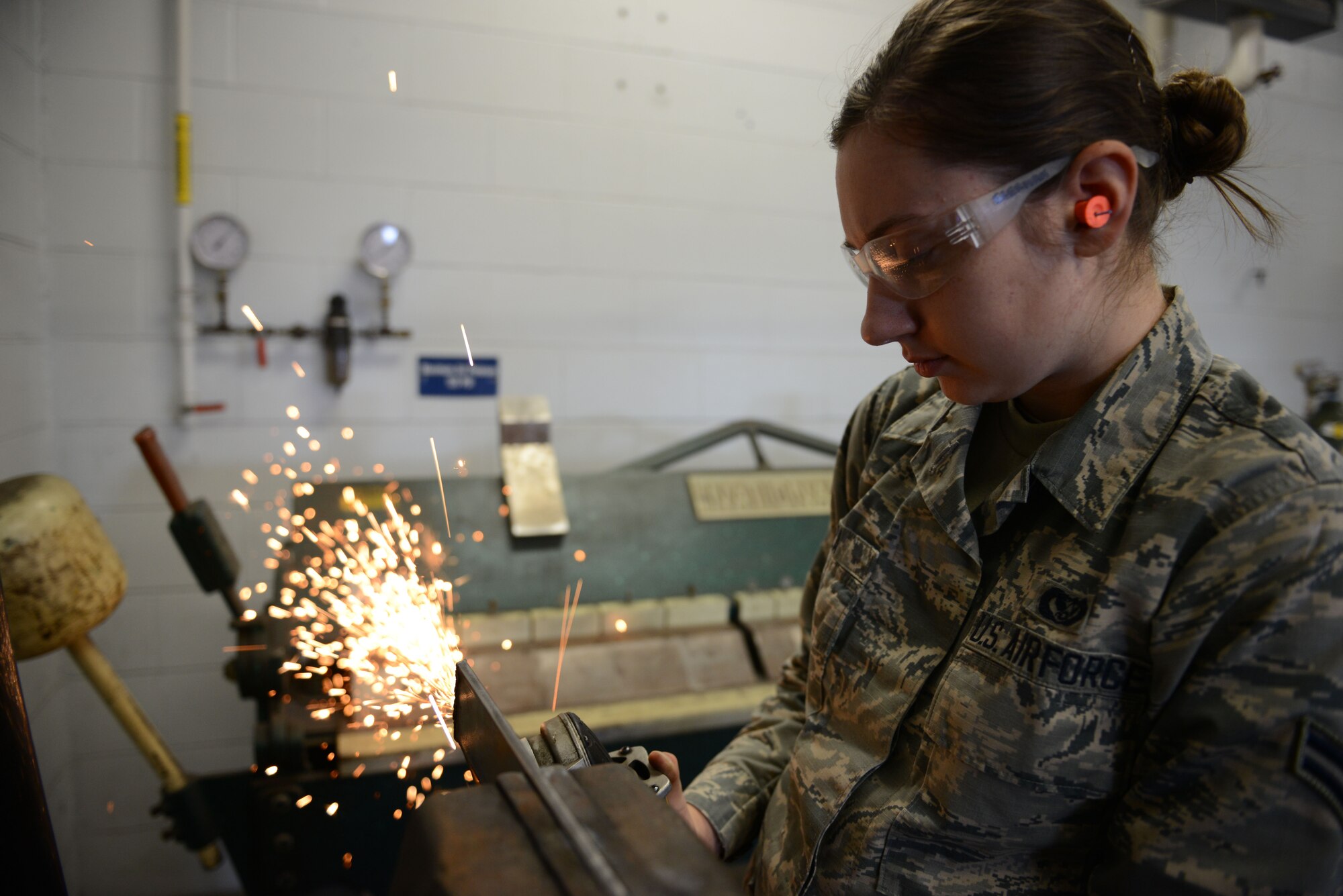 Airman 1st Class Katie Puza, a structural craftsmen assigned to the 103rd Airlift Wing, cleans a piece of metal with a grinder on Barnes Air National Guard Base, Westfield Mass., April 3, 2016. The Flying Yankees had the opportunity to use the facilities at Barnes to undergo a refresher course in welding. (U.S. Air National Guard photo by Senior Airman Emmanuel Santiago)