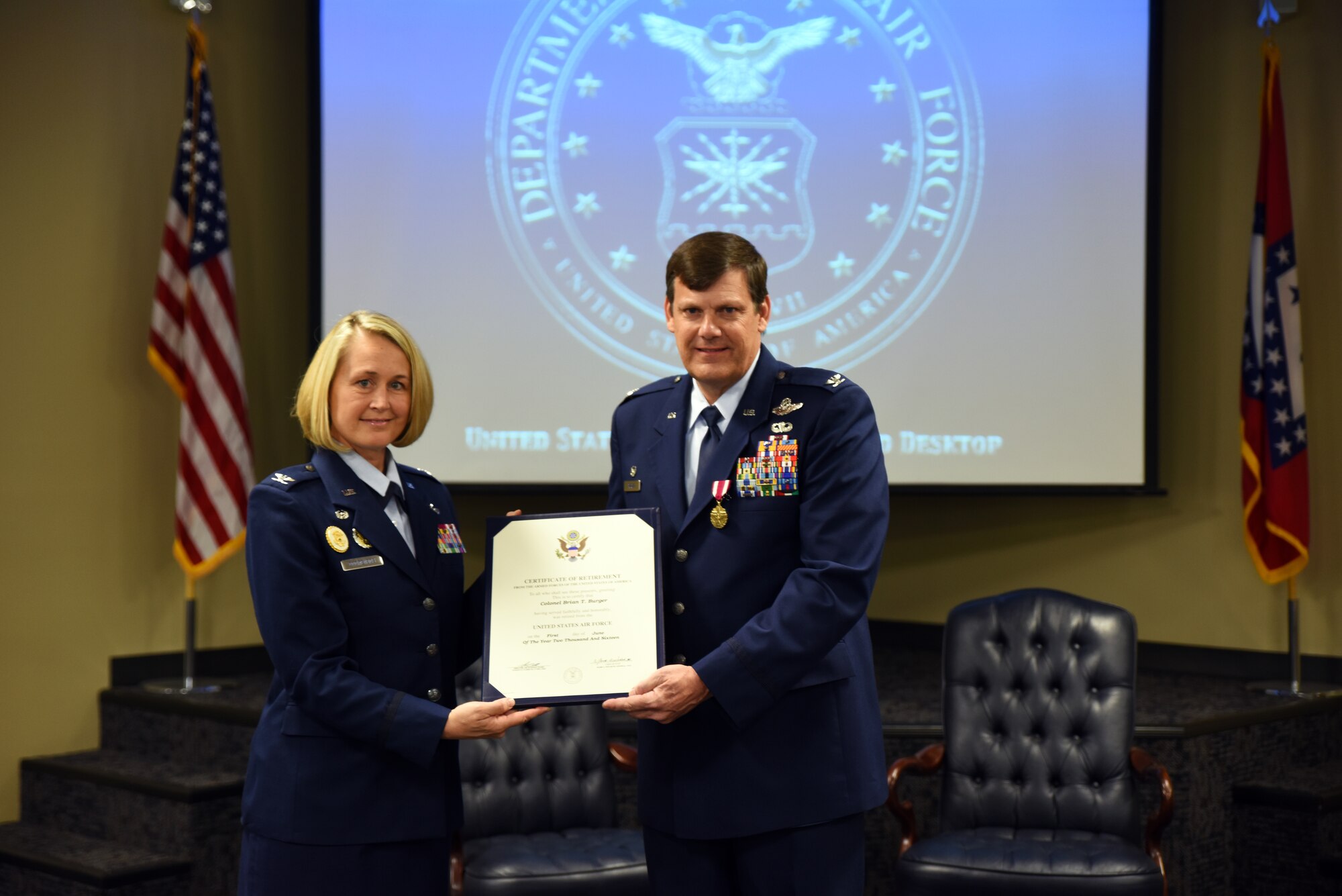 Col. Brian T. Burger, commander of the 188th Operations Group, receives his certificate of retirement from Col. Bobbi Doorenbos, 188th Wing commander, May 15, 2016, during a formal retirement ceremony at Ebbing Air National Guard Base, Fort Smith, Ark. As a command pilot, Burger logged more than 6,100 hours of military flight during his 30 year career in numerous aircraft, including the A-10C Thunderbolt II Warthog, the wing's last aircraft. (U.S. Air National Guard photo by Senior Airman Cody Martin/Released)
