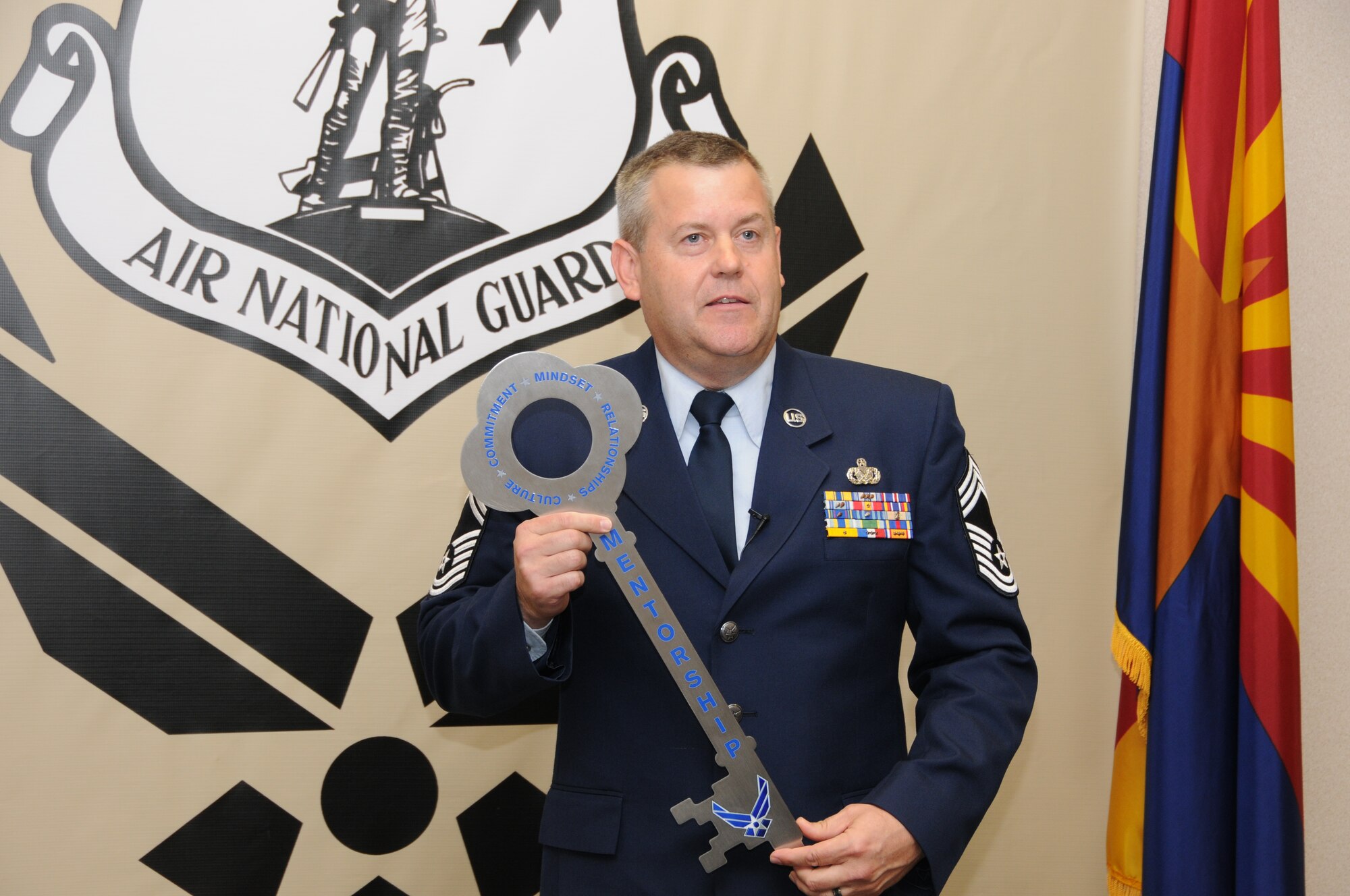 Chief Master Sgt. Bert Reid, 161st Logistics Readiness Squadron chief enlisted manager, displays a key that will be hung in the new Center for Enlisted Leadership and Learning center. The key signifies the attributes for successful mentorship: culture, commitment, mindset and relationships.