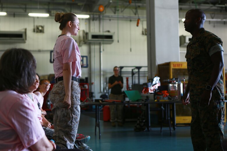 Rachelle Ugone, a military spouse, greets Sgt. Maj. Darnell Richardson, Headquarters and Headquarters Squadron sergeant major, during the 2016 Spouse Family Day, also known as Jayne Wayne Day, at Marine Corps Air Station Iwakuni, Japan, May 14, 2016. Designed to build unit and family cohesion, this event gives insight as to what military sponsors experience daily and showcases how Marines operate and train here. Participants learned about various aspects of the Marine Corps lifestyle from strict hair regulations, fitness standards and military bearing, to how Marines operate weapons, utilize specific equipment for their jobs and different professions within the organization. (U.S. Marine Corps photo by Cpl. Justin Fisher/Released)