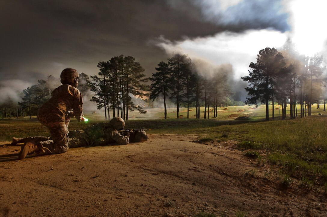 A soldier fires his M4 carbine while pyrotechnics light up the qualification range at the 2016 U.S. Army Best Warrior Competition at Fort Bragg, N.C., May 4, 2016. Army photo by Sgt. Christina M. Dion