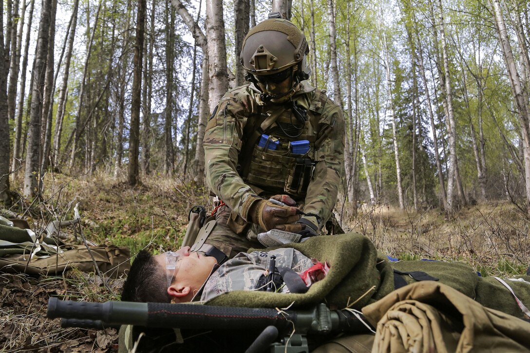 A pararescueman assesses a simulated patient’s condition during mass casualty search and rescue training at Joint Base Elmendorf-Richardson, Alaska, May 4, 2016. Air Force photo by Alejandro Pena