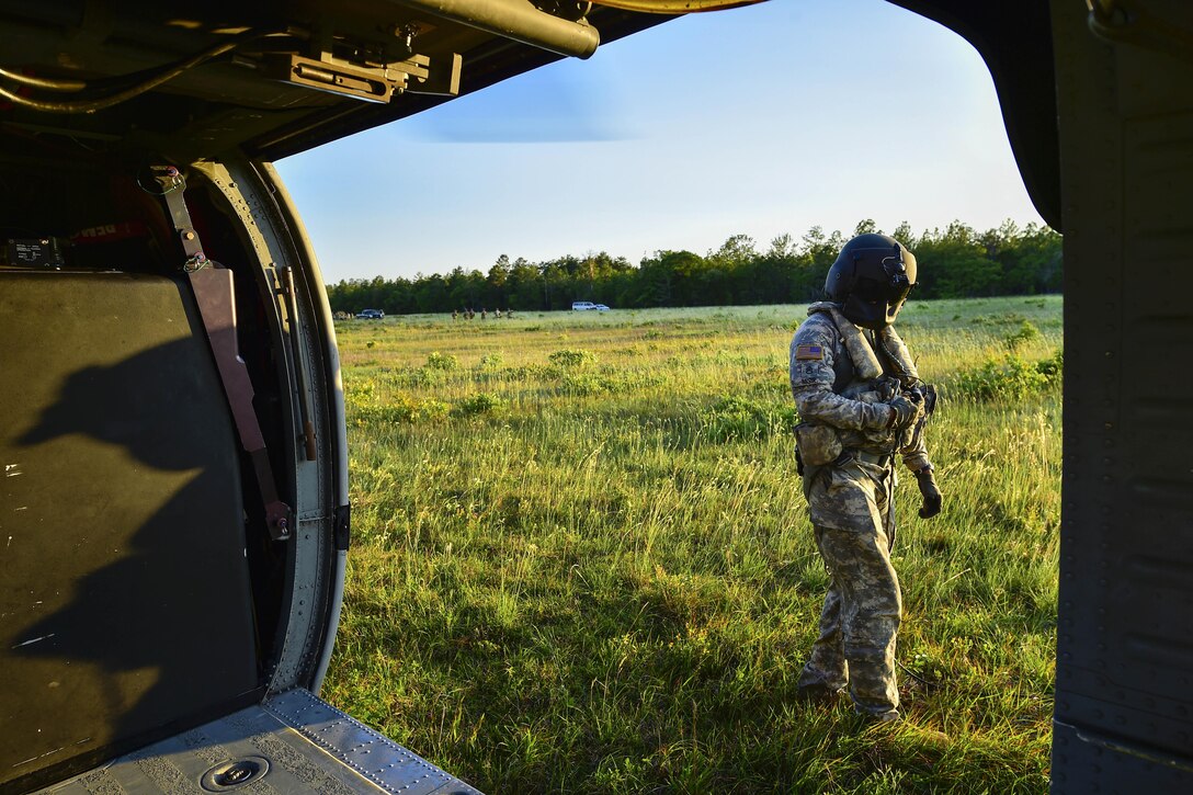 An Army crew chief takes a break outside a UH-60 Black Hawk helicopter during Emerald Warrior 16 at Hurlburt Field, Fla., May 5, 2016. The crew chief is assigned to the 11th Aviation Brigade. Air Force photo by Staff Sgt. Paul Labbe