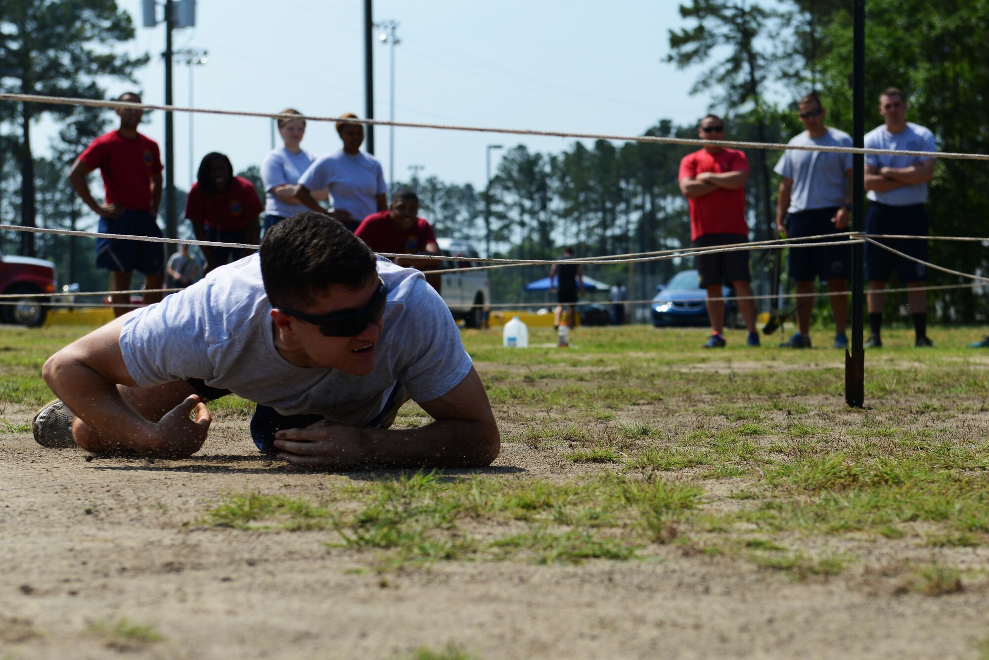 A U.S. Airman low crawls through an obstacle course during the 20th Mission Support Group Wingman Resiliency Day at Shaw Air Force Base, S.C., May 12, 2016. The various squadrons that participated in the resiliency day used teamwork to relieve stress and build resiliency through competition. (U.S. Air Force photo by Airman 1st Class Destinee Dougherty)