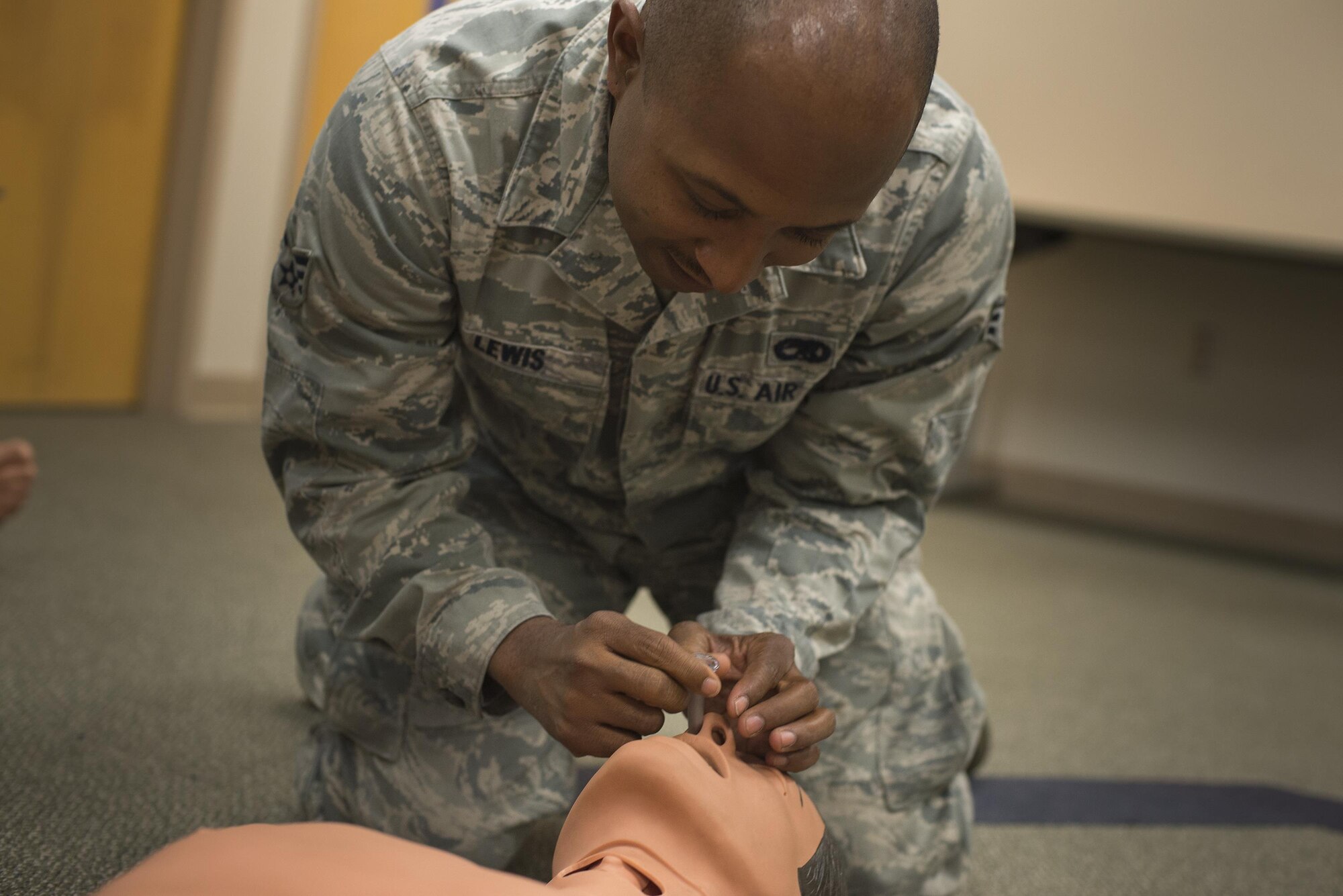 U.S. Air Force Senior Airman Michael Lewis, 23d Aircraft Maintenance Squadron hydraulic craftsman, uses a nasopharyngeal airway tube on a training mannequin, May 13, 2016, at Moody Air Force Base, Ga. When performing self-aid buddy care, airway management takes priority over managing blood loss. (U.S. Air Force photo by Airman Daniel Snider/Released)