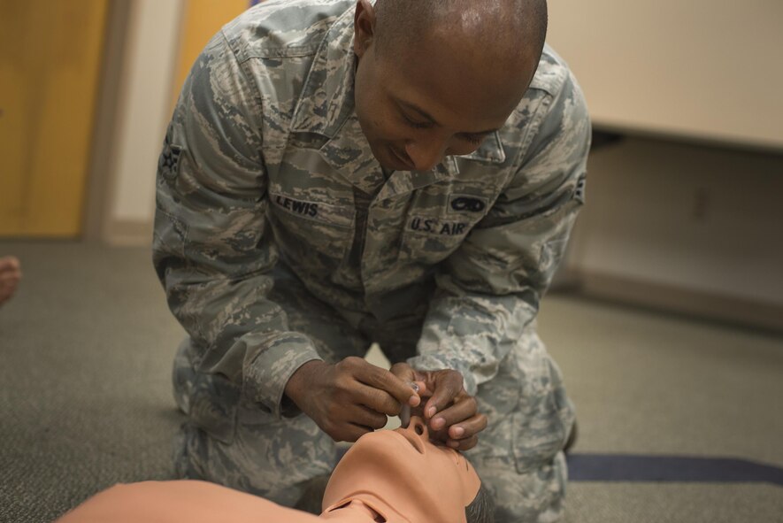 U.S. Air Force Senior Airman Michael Lewis, 23d Aircraft Maintenance Squadron hydraulic craftsman, uses a nasopharyngeal airway tube on a training mannequin, May 13, 2016, at Moody Air Force Base, Ga. When performing self-aid buddy care, airway management takes priority over managing blood loss. (U.S. Air Force photo by Airman Daniel Snider/Released)