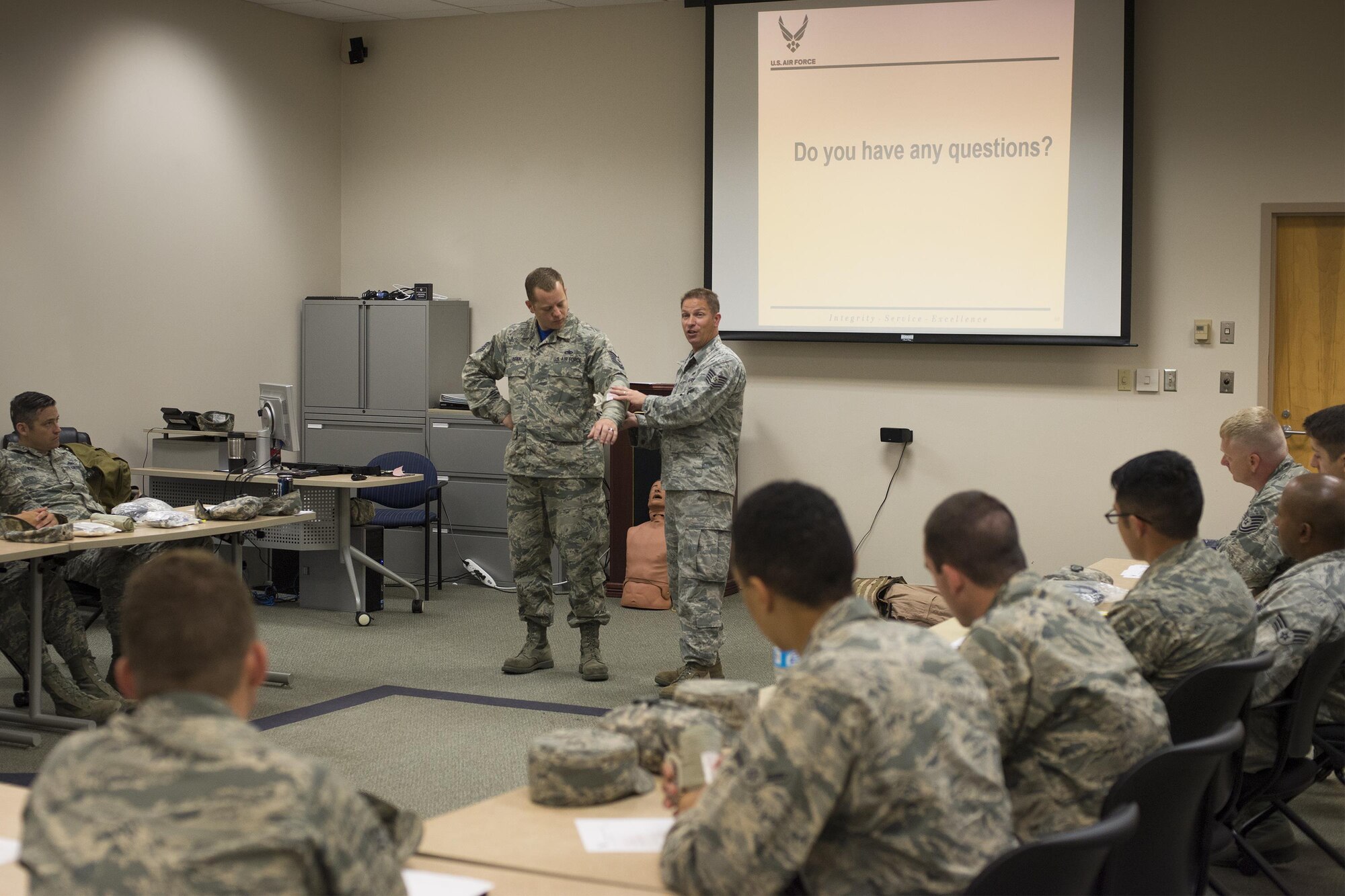 U.S. Air Force Tech. Sgt. Kevin Strickland, 23d Maintenance Operations Flight, and Tech. Sgt. David Asher, 23d Aircraft Maintenance Squadron, both self-aid buddy care instructors, demonstrate proper use of emergency bandages, May 13, 2016, at Moody Air Force Base, Ga. Using combat gauze and bandages correctly helps blood clot more quickly and could possibly save a life. (U.S. Air Force photo by Airman Daniel Snider/Released)