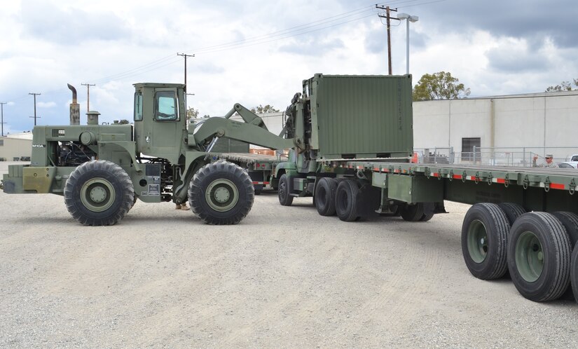 A fork lift loads a Quadcon container on to a M-872 Series 40-foot, 34-ton flatbed semitrailer, bound for Canada. Soldiers from the 729th Transportation Company, Fresno, Calif., and Marines from the 3rd Air Naval Gunfire Liaison Company worked together, preparing for Operation Maple Resolve, which is being conducted at Canadian Forces Base Wainwright, east of Edmonton, Canada. Operation Maple Resolve is the Canadian Forces largest training exercise of the year.