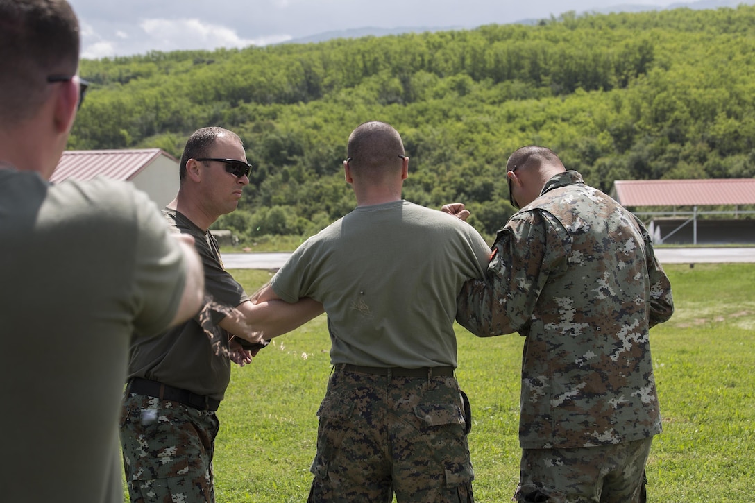 A Bosnian soldier demonstrates taser firing techniques during a non-lethal weapons class as part of  exercise Platinum Wolf 2016 at Peacekeeping Operations Training  Center South Base in Bujanovac, Serbia, May 13, 2016. Seven countries including Bosnia, Bulgaria, Macedonia, Montenegro, Slovenia, Serbia, and the United States joined together to enhance their ability to work together and master the use on non-lethal weapons systems. (U.S. Marine Corps photo by Sgt. Sara Graham)