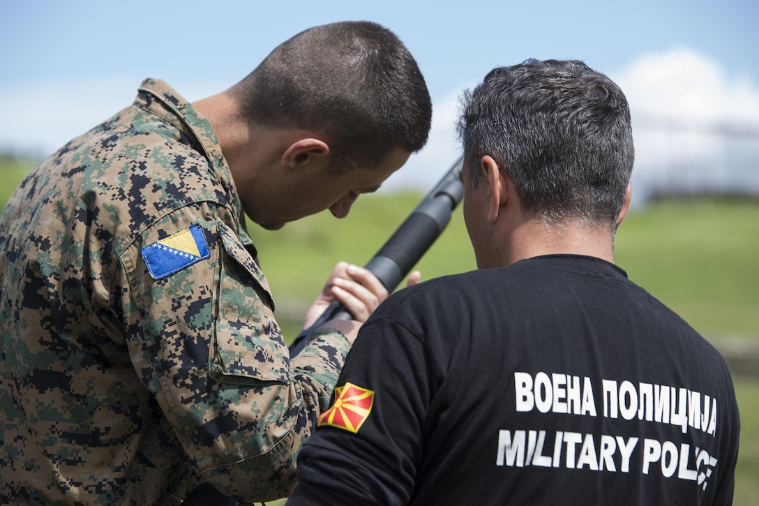 Sgt. Maj. Sasha Toshevski, first sergeant and non-lethal weapons instructor with the Macedonian Special Forces Regiment, instructs a Bosnian soldier on shotgun loading techniques while training in a non-lethal weapons class, during exercise Platinum Wolf 2016 at Peacekeeping Operations Training  Center South Base in Bujanovac, Serbia, May 13, 2016. Seven countries including Bosnia, Bulgaria, Macedonia, Montenegro, Slovenia, Serbia, and the United States joined together to enhance their ability to work together and master the use on non-lethal weapons systems. (U.S. Marine Corps photo by Sgt. Sara Graham)