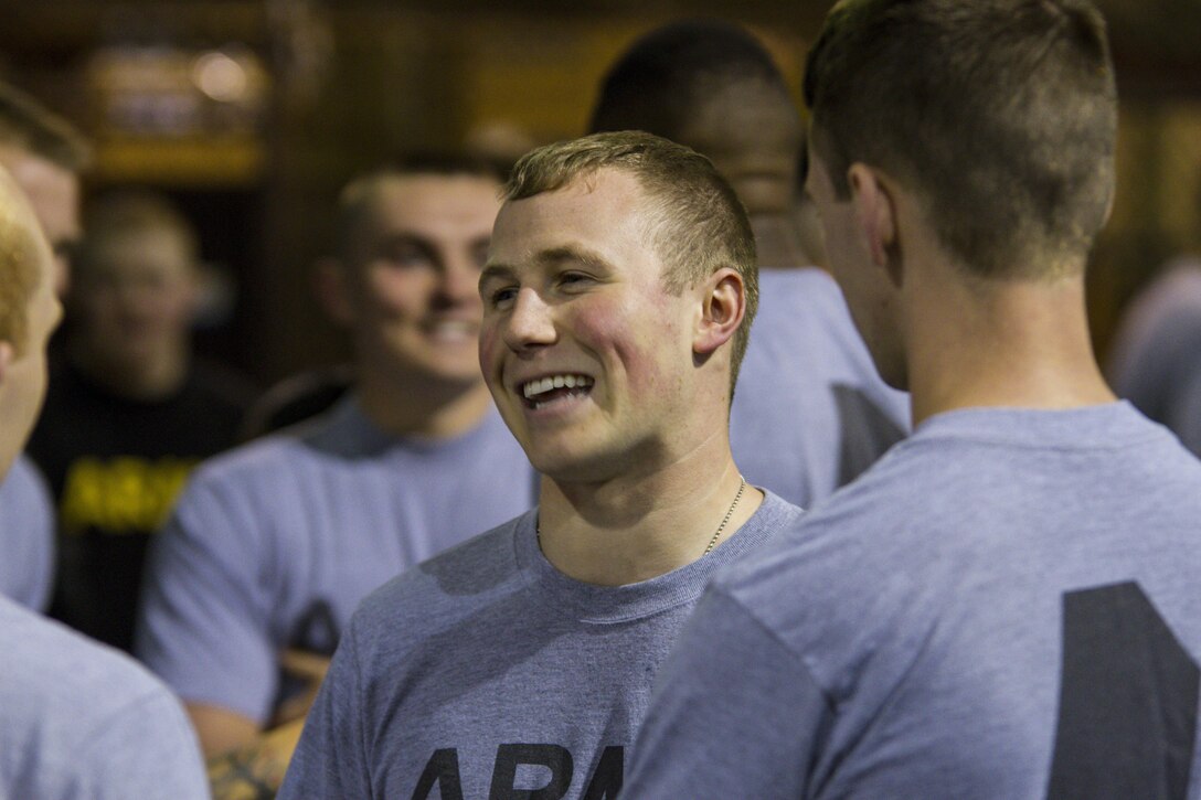Spc. Cameron Cussen, a U.S. Army Reserve motor transport operator from Garden City, Michigan, assigned to the 303rd Military Police Company, laughs with fellow Soldiers between events during the Army Physical Fitness Test in Jackson, Michigan, May 14. The test is held annually and consists of a two-minute push-up and sit-up events and a timed two-mile run. The events measure the muscular strength and endurance of each Soldier, which ensures they have what it takes to uphold the Army's fitness standard. (U.S. Army photo by Sgt. Audrey Hayes)
