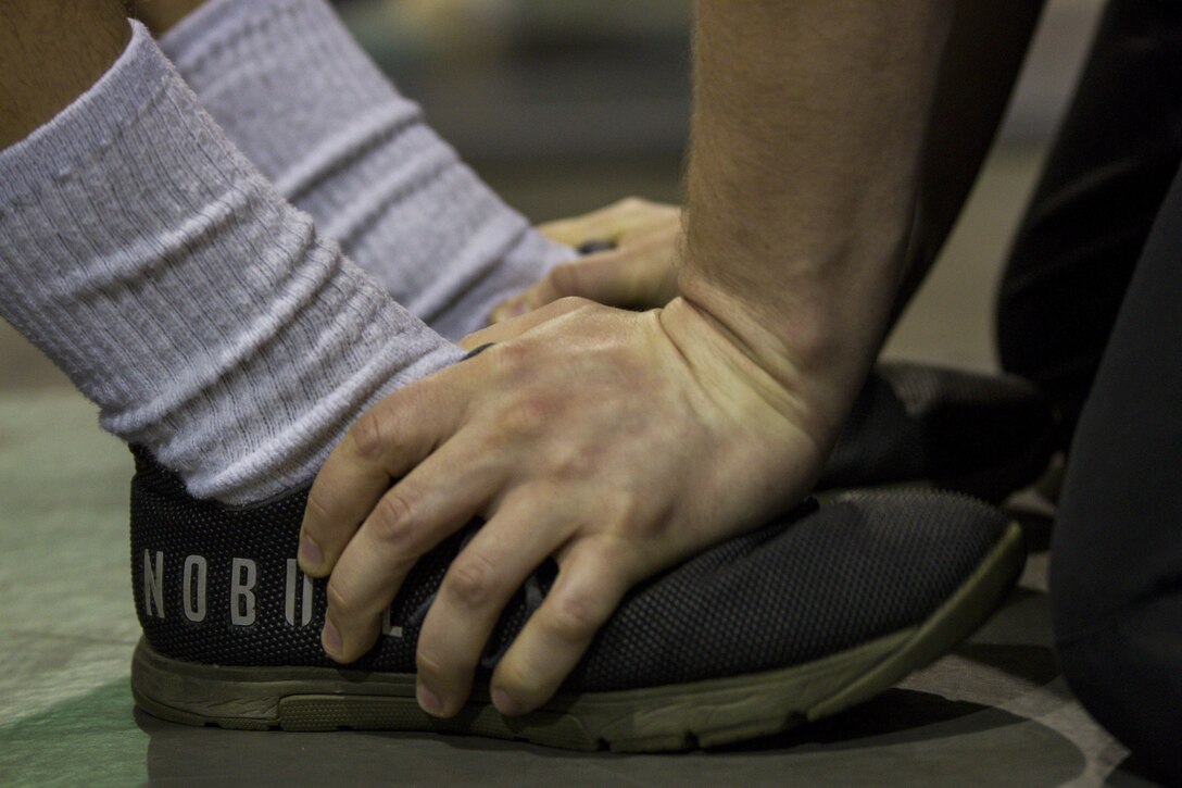 A U.S. Army Reserve Soldier assigned to the 303rd Military Police Company holds a fellow Soldier's feet for the sit-up event during the Army Physical Fitness Test in Jackson, Michigan, May 14. The test is held annually and consists of a two minute push-up and sit up-events and a timed two-mile run. The test measures the muscular strength and endurance of each Soldier, ensuring they have what it takes to uphold the Army's fitness standard. (U.S. Army photo by Sgt. Audrey Hayes)