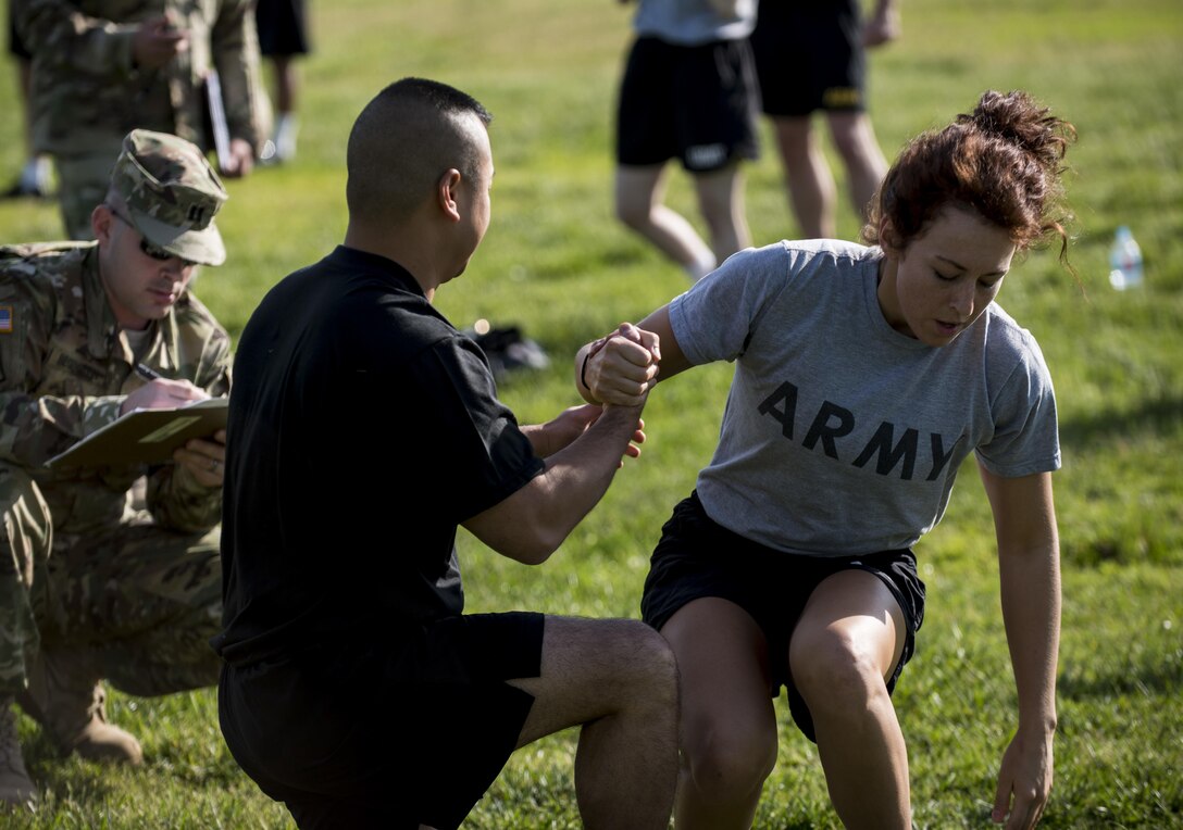 A U.S. Army Reserve Soldier from the 200th Military Police Command's headquarters company helps another off the ground after she completes her sit-up event in the Army Physical Fitness Test, May 14, during battle assembly at Fort Meade, Maryland. (U.S. Army photo by Master Sgt. Michel Sauret)