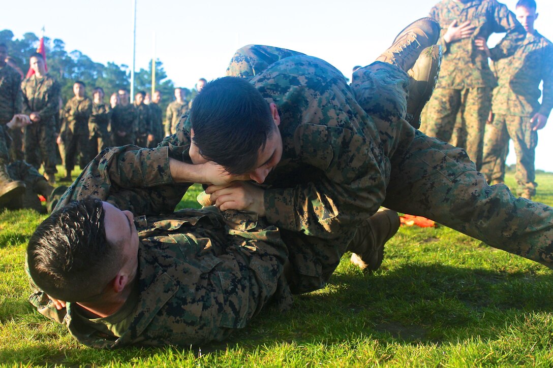 Marines from the Marine Corps Detachment practicing newly learned ground fighting techniques on one another during a grappling session.