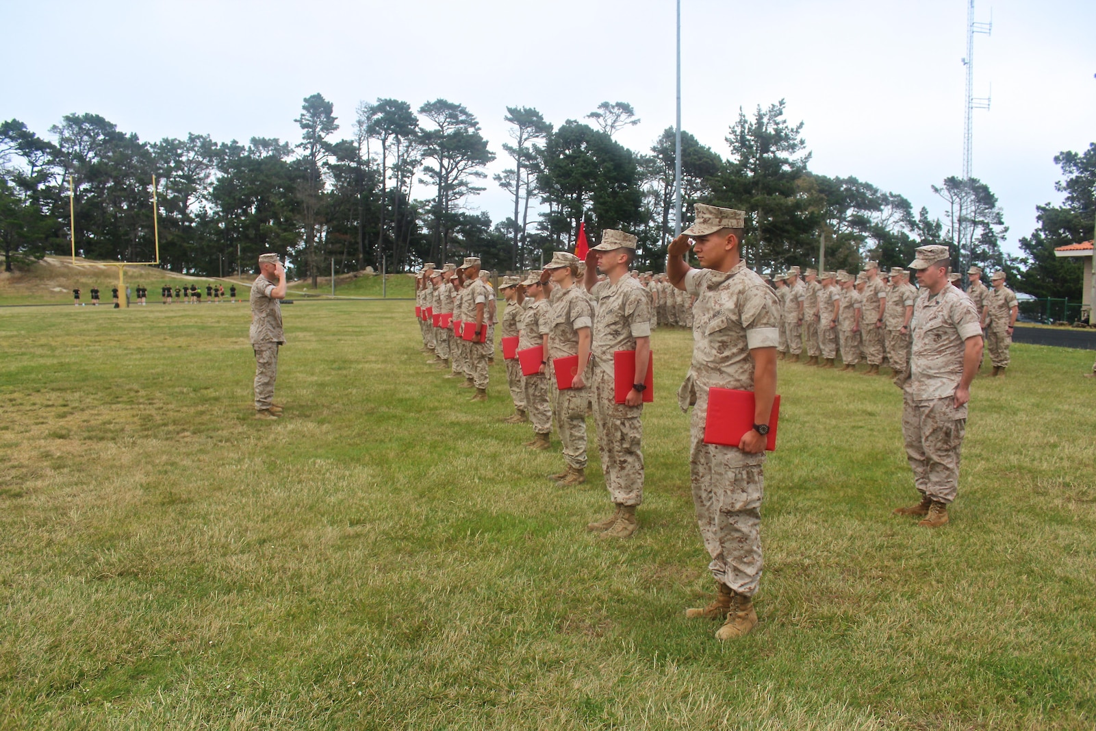 The Marine Corps Detachment's newest Lance Corporals and Privates First Class salute after being promoted during a promotion formation held on 1 May, 2016.