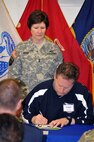 Maj. Gen. Margaret W. Boor, commanding general of the U.S. Army Reserve's 99th Regional Support Command headquartered at Joint Base McGuire-Dix-Lakehurst, New Jersey, looks on as Brian Mueller from Prudential Financial signs a statement of support that his company will place an emphasis on hiring veterans.  The support signing on May 13 at JBMDL's Army Reserve Mobilization Museum concluded a two-day Employer Support of the Guard and Reserve "Boss Lift" event at the base.