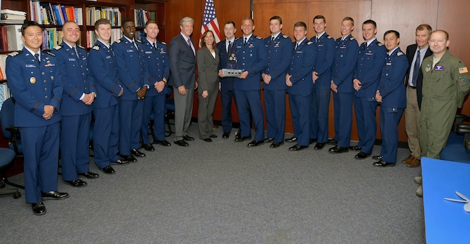 Center: Senior Boeing officials Dennis O'Donahue and Patricia Stevens, and the U.S. Air Force Academy's Dean of the Faculty, Brig. Gen. Andrew Armacost, pose for a photo with the team of Academy cadets and faculty members who won the Boeing Tri-Service Academy Capstone Competition May 6. This year's competition required cadets and midshipmen from the U.S. Military Academy, the U.S. Air Force Academy and the U.S. Naval Academy to research methods to control a swarm of unmanned aerial vehicles. (U.S. Air Force photo/Jason Gutierrez)  