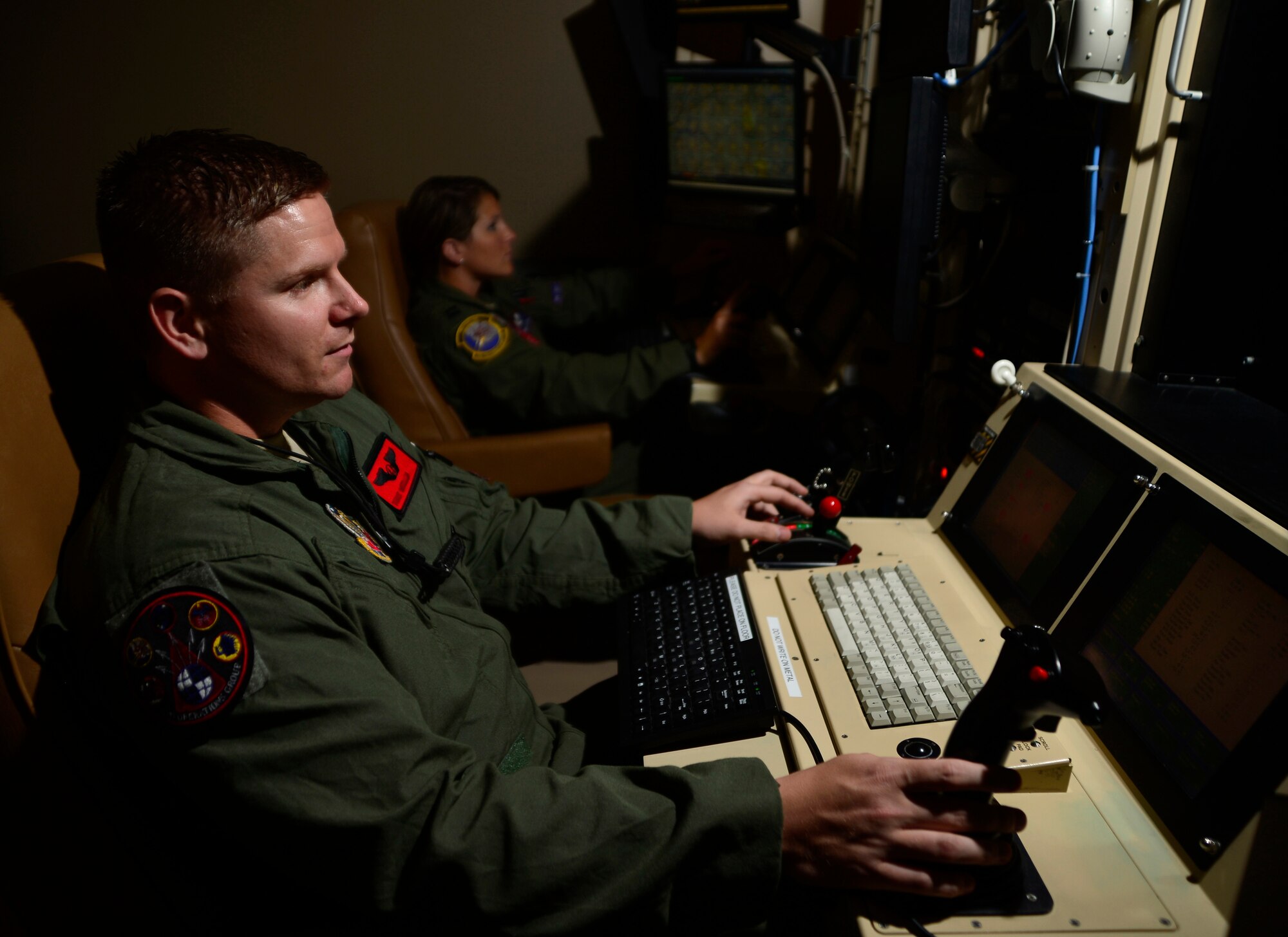 Tech. Sgt. William, 432nd Wing sensor operator, left, and Capt. Amanda, 432nd Wing pilot fly a MQ-9 simulator training mission May 10, 2016, at Creech Air Force Base, Nevada. President Harry S. Truman led the effort to establish Armed Forces Day a single holiday for citizens to come together and thank our military members for their patriotic service in support of our country. (U.S. Air Force photo by Senior Airman Christian Clausen/Released)