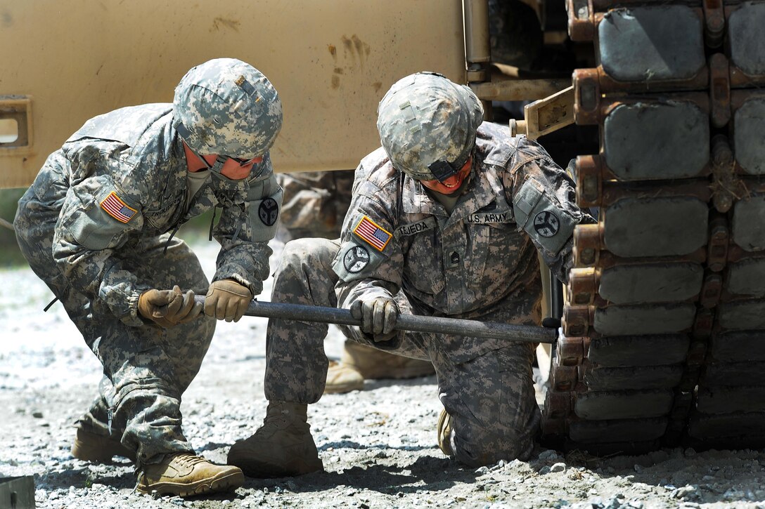 Army Pfc. Harlan Troutman, left, and Army Sgt. 1st Class Joseph Tejeda use a wrench to tighten bolts on a an M1A2 Abrams tank during the Gen. Gordon Sullivan Cup best tank crew competition at Fort Benning, Ga., May 3, 2016. Troutman and Tejeda are assigned to the Tennessee Army National Guard’s H Troop, 2nd Squadron, 278th Armored Cavalry Regiment. Army photo by Sgt. 1st Class Jon Soucy