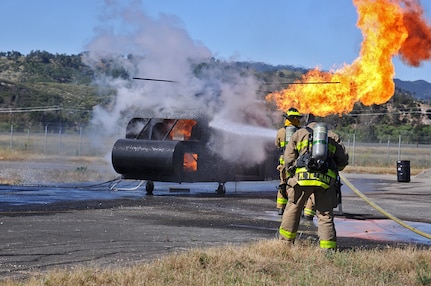 JOLON, Calif. – Fire fighting Soldiers with the 614th Engineer Detachment attack a helicopter-fuselage fire during a multi-unit mass casualty exercise at Fort Hunter Liggett’s Tusi Airfield, May 9. The realistic exercise was apart of the Fort’s 16th Annual Warrior Exercise and the scenario encompassed a simulated helicopter crash, which had burst into flames and 32 casualties laid scattered around the helicopter.   (U.S. Army photo by Sgt. Kimberly Browne, 350th Public Affairs Detachment)