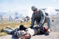 JOLON, Calif. – A combat medic with the 614th Engineer Detachment calms a simulated casualty during a multi-unit mass casualty exercise at Fort Hunter Liggett’s Tusi Airfield, May 9. The exercise was apart of the Fort’s 16th Annual Warrior Exercise and the scenario encompassed a simulated helicopter crash, which had burst into flames and 32 casualties laid scattered around the helicopter. (U.S. Army photo by Sgt. Kimberly Browne, 350th Public Affairs Detachment)