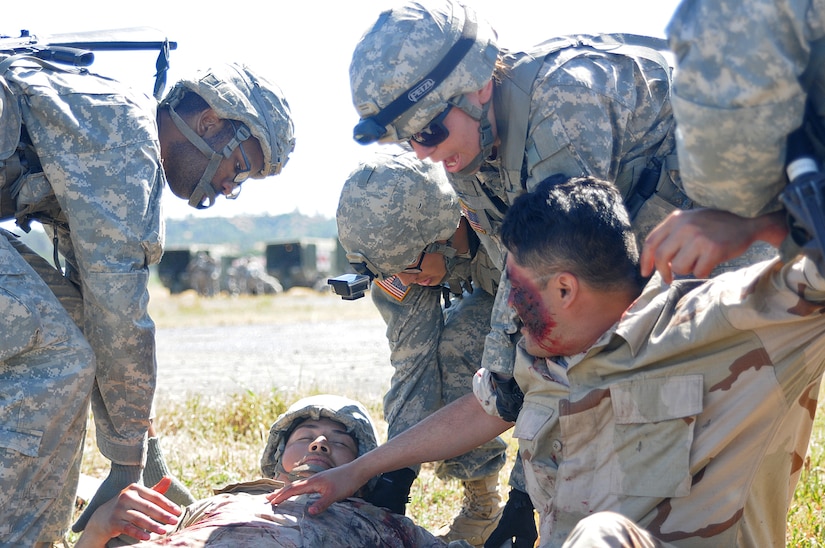 JOLON, Calif. – Combat Medics with various units evaluate and assist a two simulated casualties during a multi-unit mass casualty exercise at Fort Hunter Liggett’s Tusi Airfield, May 9. The realistic exercise was apart of the Fort’s 16th Annual Warrior Exercise and the scenario encompassed a simulated helicopter crash, which had burst into flames and 32 casualties laid scattered around the helicopter. (U.S. Army photo by Sgt. Kimberly Browne, 350th Public Affairs Detachment)