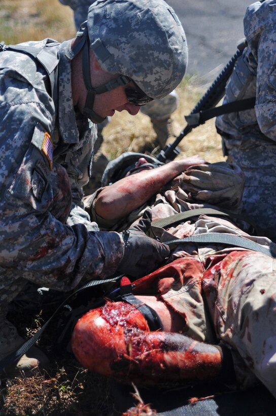 JOLON, Calif. – A combat medic adjusts the straps of a litter securing a simulated casualty during a multi-unit mass casualty exercise at Fort Hunter Liggett’s Tusi Airfield, May 9. The realistic exercise was apart of the Fort’s 16th Annual Warrior Exercise and the scenario encompassed a simulated helicopter crash, which had burst into flames and 32 casualties laid scattered around the helicopter, where the medics were to give aid and evacuate if needed. (U.S. Army photo by Sgt. Kimberly Browne, 350th Public Affairs Detachment)