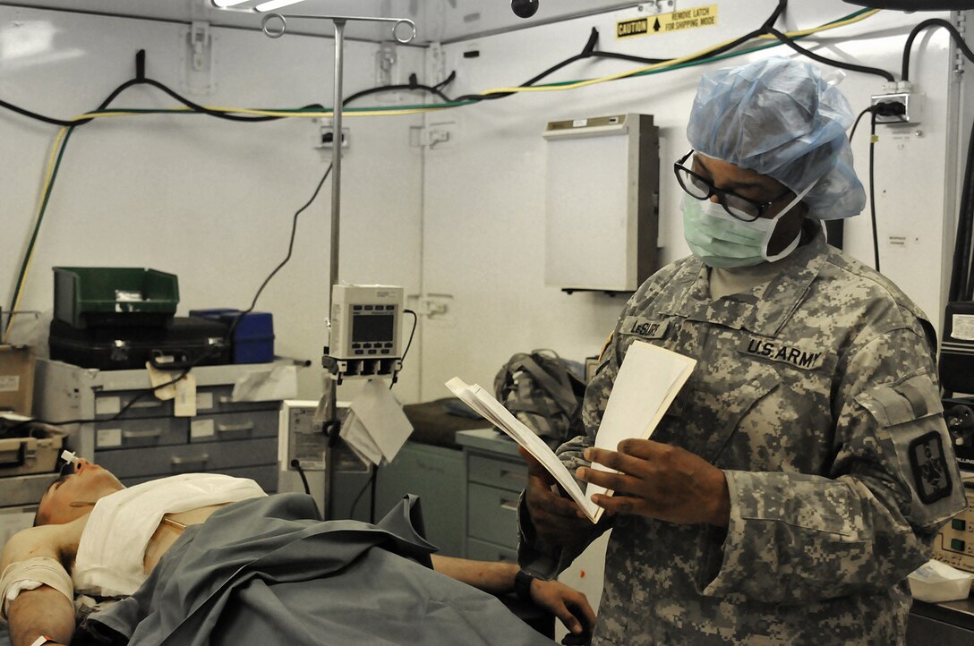 JOLON, Calif. – Lt. Col. Anita Lesure, head nurse of the operating room and Soldier with the 801st Combat Support Hospital, looks over a simulated casualty’s chart to decide further treatment during a mass casualty exercise at Fort Hunter Liggett, May 9. The realistic exercise was apart of the Fort’s 16th annual Warrior Exercise and the scenario encompassed a simulated helicopter crash, which had burst into flames and 32 casualties laid scattered around the helicopter, where the medics gave battlefield aid and evacuated the casualties to the CSH.  (U.S. Army photo by Sgt. Kimberly Browne, 350th Public Affairs Detachment)