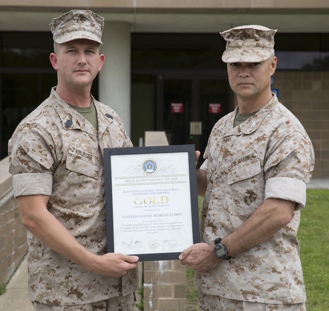 Col. John E. Walker Jr., right, Commanding Officer of Marine Corps Intelligence Schools, and Master Sgt. Eldar Krueger, MCIS S-6 Chief, display the Department of Defense Intelligence and Security Learning Enterprise Gold Level of Achievement Award for 2015. MCIS received the Gold Level award for being the top school, chosen from a field of 52 formal learning centers encompassing $2 billion in resources and assets across the Department of Defense.