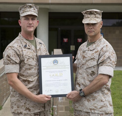Col. John E. Walker Jr., right, Commanding Officer of Marine Corps Intelligence Schools, and Master Sgt. Eldar Krueger, MCIS S-6 Chief, display the Department of Defense Intelligence and Security Learning Enterprise Gold Level of Achievement Award for 2015. MCIS received the Gold Level award for being the top school, chosen from a field of 52 formal learning centers encompassing $2 billion in resources and assets across the Department of Defense.