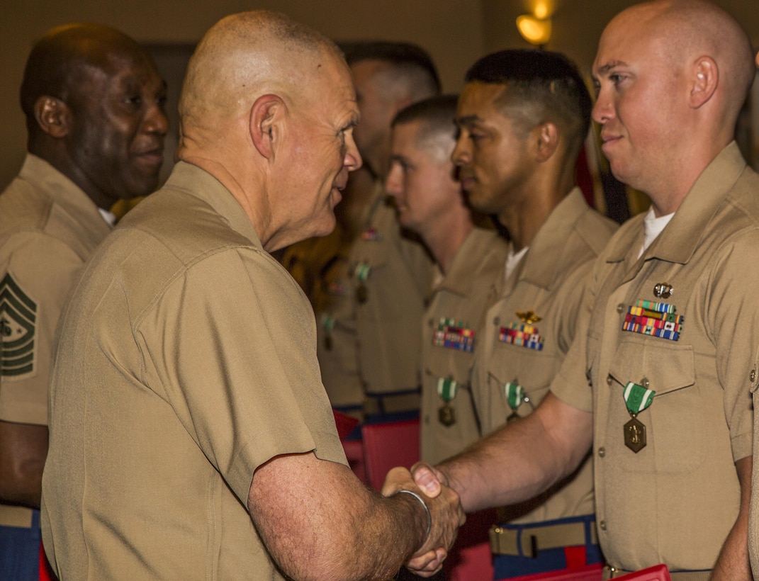 Gen. Robert B. Neller, Commandant of the Marine Corps (left), congratulates Staff Sgt. Christopher Smith, the 2015 Reserve Career Planner of the Year during the Commandant of the Marine Corps Combined Awards Ceremony, held at Marine Corps Base Quantico, Va., May 11, 2016. Smith, the career planner from 3rd Air Naval Gunfire Liaison Company, Force Headquarters Group, Marine Forces Reserve, was awarded the Navy and Marine Corps Commendation Medal for his hard work and dedication. The ceremony also recognized superior recruiters, drill instructors, combat instructors, Marine security guards, career planners and Semper Fit male and female athletes of the year. 