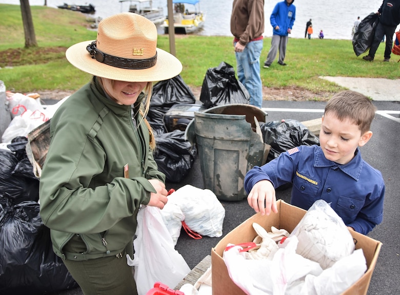 Park Ranger Alicia Palmer, Baltimore District, U.S. Army Corps of Engineers, helps Grant Taylor, 8, sort through trash collected during the Raystown Lake Cleanup Day, May 7, 2016.  Taylor was among the 130 volunteers that came together to collect debris from remote areas of Raystown Lake’s 110 miles of shoreline during the annual event. 