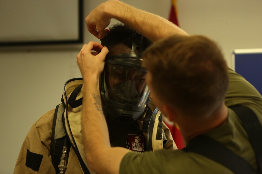 A Marine with the Chemical Biological Radiological and Nuclear (CBRN) unit receives assistance putting on a hazardous material suit during Assessment Consequence Management training aboard Marine Corps Air Station Miramar, Calif., May 6. The ACM training is conducted by CBRN once a month to maintain mission readiness. (U.S. Marine Corps photo by Pfc. Liah Kitchen/Released)