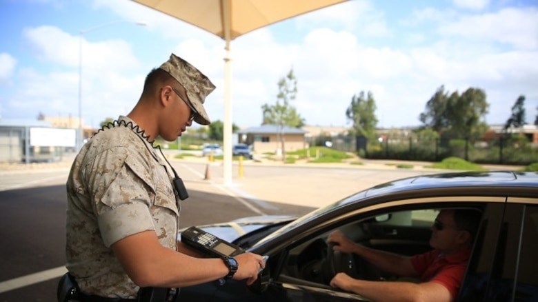 Cpl. Siheng Yang, a military police officer with the Provost Marshal’s Office, checks a driver’s identification before allowing him aboard Marine Corps Air Station Miramar, Calif., March 22. Identification cards are checked by military policemen before drivers are allowed aboard the installation. (U.S. Marine Corps photo by Sgt. Michael Thorn/Released)