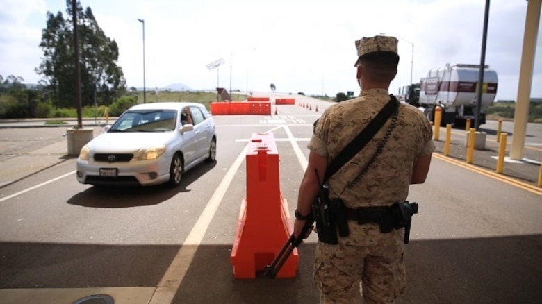 A military police officer stands guard at the east gate outside of Marine Corps Air Station Miramar, Calif., March 22. Military policemen provide the first line of defense at the gates for the installation by checking every driver that comes through. (U.S. Marine Corps photo by Sgt. Michael Thorn/Released)