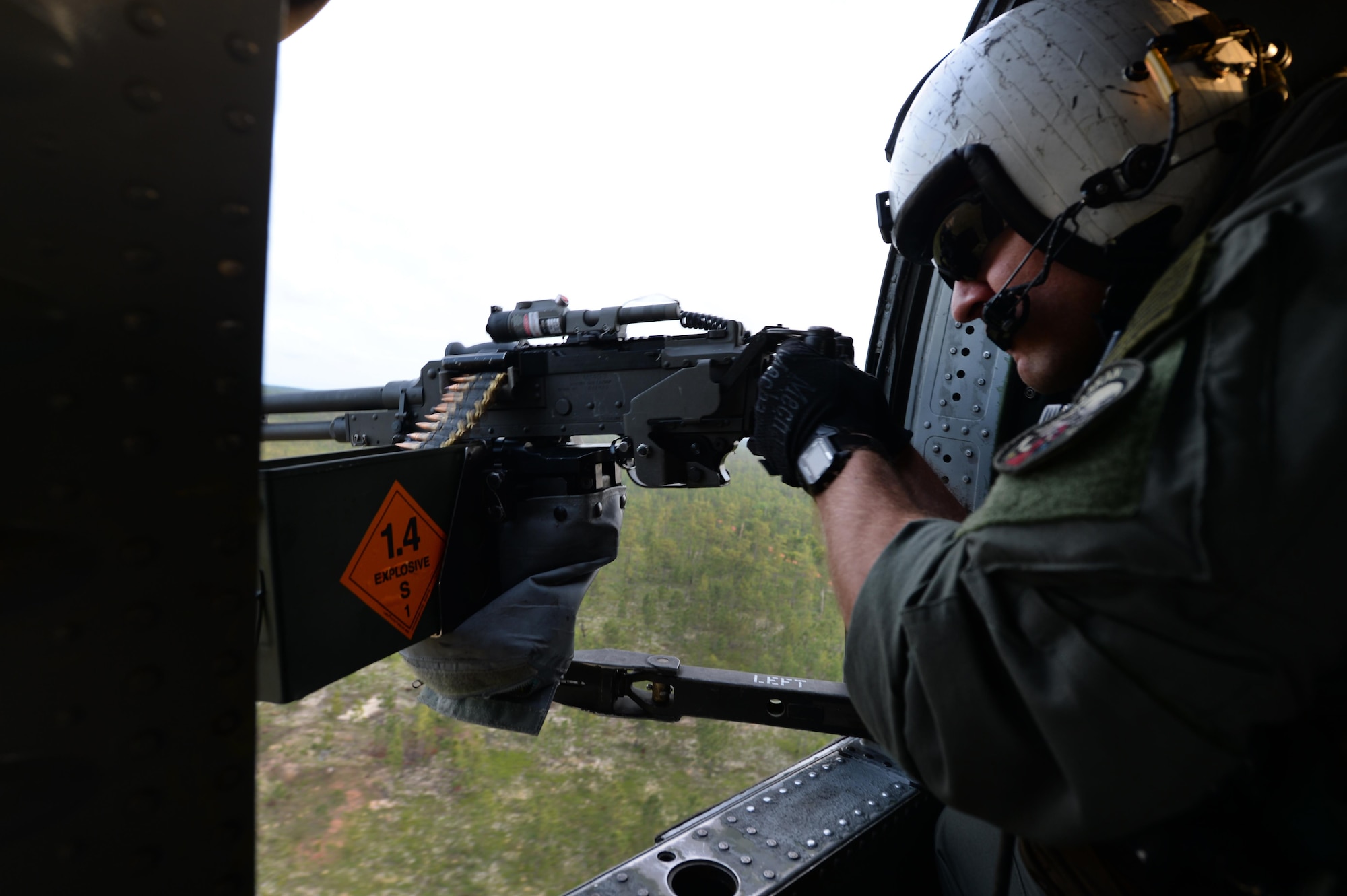 A U.S. Navy Sailor assigned to the Helicopter Sea Combat Squadron 26 Chargers fires from a MH-60 Seahawk during Emerald Warrior 2016 at Hurlburt Field, Fla., May 12, 2016. Emerald Warrior is a U.S. Special Operations Command-sponsored mission rehearsal exercise during which joint special operations forces train to respond to real and emerging worldwide threats. (U.S. Air Force photo by Staff Sgt. Sandra Welch)                                                                                                                                                                                                             