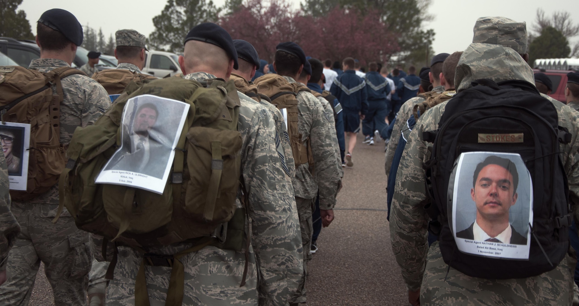 Ninetieth Security Forces Group defenders with memorial photos of fallen defenders pinned to their back packs march in formation May 16, 2016, during a memorial 5-kilometer ruck-run in honor of National Police Week on F.E. Warren Air Force Base, Wyo. Each member who participated in the ruck-portion of the event carried a photo of a fallen comrade. (U.S. Air Force photo by Senior Airman Brandon Valle)